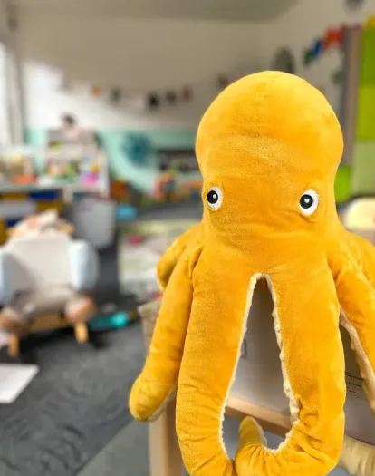 Großer gelber Stoff-Oktopus sitzt im Spielbereich einer Kindertagespflege